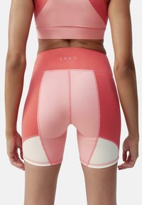 Hoge taille, knielange shorts in een gradiënt van roze tinten met contrasterende lichtroze panelen en flatlock naden. Gemaakt van rekbaar materiaal.