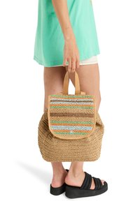 Woven tan backpack with a striped multi-colored flap, featuring accents of orange, blue, and brown, and two top handles.