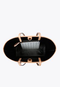 Grote beige leren tote bag met een zwarte binnenkant, voorzien van twee handvaten, een magnetische sluiting en een verwijderbare zilveren pouch aan de binnenkant.