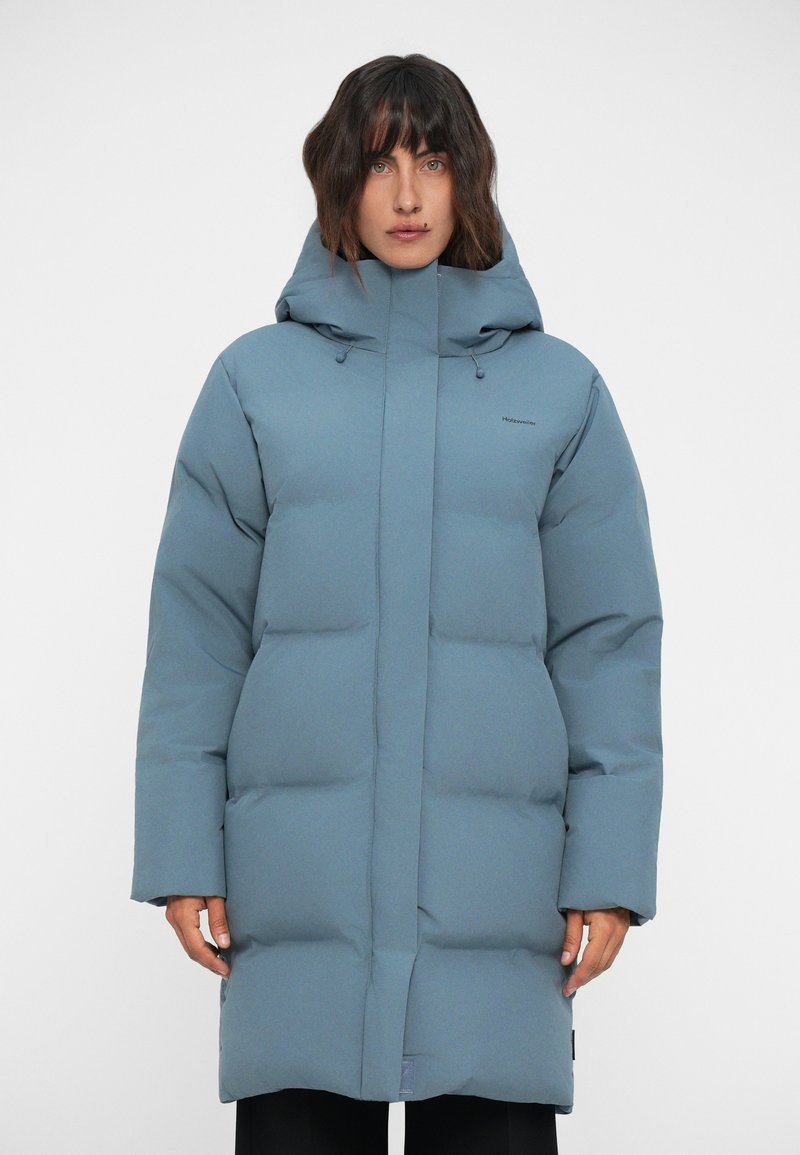 Blå vadderad parkas med huva, med en rak passform, långa ärmar och en jämn yta. Enkelt design med dragkedja fram och minimal branding.