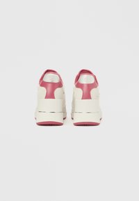 Αθλητικά παπούτσια με άνω μέρος από λευκό σουέντ και ροζ δέρμα, υφασμένη πίσω πλευρά και χοντρή λευκή σόλα πλατφόρμα με ασημένια λεπτομέρεια.