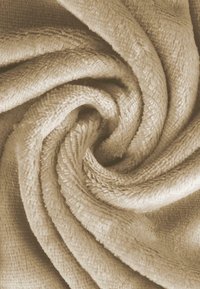 Beige, textured fabric towel in a spiral fold, showcasing a soft, absorbent surface with a slight sheen and dense fibers.