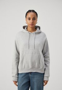Gray hooded sweatshirt made of cotton blend. Features a front pocket, drawstring hood, and ribbed cuffs. Casual, relaxed fit.