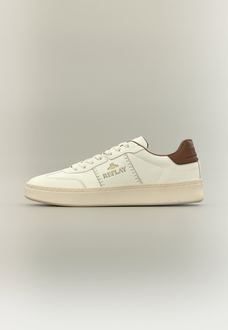 Λευκό δερμάτινο αθλητικό παπούτσι με καφέ λεπτομέρειες, που έχει υφή στην σόλα, διακριτικό ράψιμο και λεπτομέρειες με χρυσό λογότυπο στο πλάι.