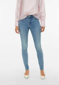 Šviesiai mėlynos plėšiamos džinsinės kelnės, pagamintos iš džinso audinio, su vidutinio aukščio liemeniu ir klasikiniu penkių kišenių dizainu. Derinamos su šviesiai rožine palaidine.