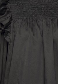 Abito nero con corpetto arricciato e maniche a volant, realizzato in tessuto leggero, caratterizzato da un design ampio e fluido.