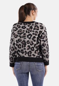 Maglione con stampa leopardata in grigio, nero e beige, con orlo e polsini a coste neri. Presenta una vestibilità rilassata e una texture morbida.