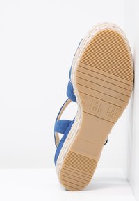 Sandalo espadrille in suede blu con suola in juta intrecciata. Presenta una suola piatta in gomma testurizzata e un logo in rilievo sulla soletta.