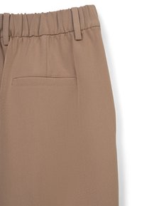 Pantalon en tissu texturé marron avec une taille élastique, doté d'une poche arrière et d'un design à plat à l'avant, de coupe ajustée.