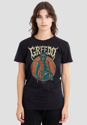 Woman wearing a black Star Wars t-shirt featuring Greedo holding a gun with the word "GREEDO" above and an orange circle background.