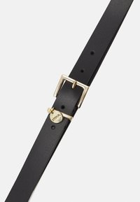 Cintura in pelle nera con fibbia in metallo dorato rettangolare, piccolo ciondolo circolare con logo e diversi fori per regolazione lungo il cinturino.