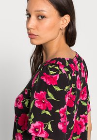 Vestido preto floral com flores vibrantes em rosa e verde, mangas curtas e decote redondo com pregas subtis nas costas.