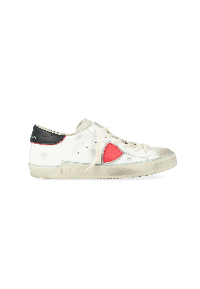 Sneakers bianchi in pelle con un patch a forma di cuore rosso, lacci beige e un dettaglio nera sul tallone. Aspetto usato con leggere abrasioni sulle suole.