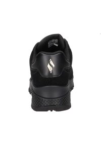 Czarne buty sportowe z gładką skórzaną cholewką, wyściółką w okolicy kostki oraz teksturowaną gumową podeszwą. Posiadają małe srebrne logo na pięcie.