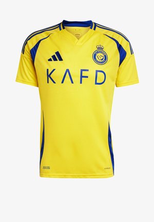 Žlutý fotbalový dres s modrými akcenty, s designem ve tvaru V, krátkým rukávem a výrazným modrým textem "KAFD".