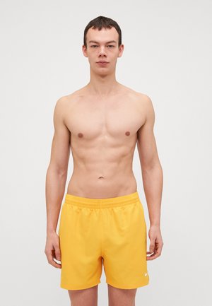Shorts de bain jaunes avec une taille élastique et des poches latérales, fabriqués en tissu léger ; présente un petit logo blanc sur la jambe.