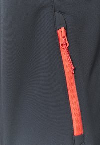 Czarna tkanina o gładkiej fakturze z pomarańczowym zamkiem po boku, który dodaje funkcjonalności i kontrastuje z kolorem.