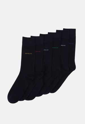 Sex par svarta bomullssockor med ribbade muddar och färgglad "GANT"-logga i broderi i gult, rött, blått, grönt och turkos.