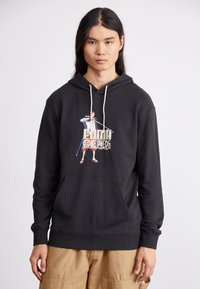 Black hoodie made of cotton with a front pocket. Features a colorful graphic print of a character holding a sword. Drawstring hood.