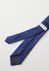 Cravate bleu marine avec un motif de rayures diagonales en bleu clair. Texture lisse, pointe pointue, et une étiquette portant la mention "PIER ONE" au dos.