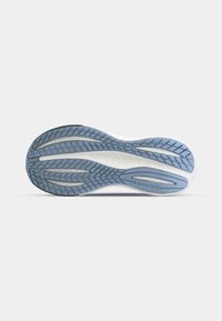 Suola di scarpa da corsa con un motivo in gomma blu testurizzato, caratterizzata da elementi bianchi e grigi. Il nome del marchio "Saucony" è visibile.