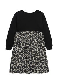 Schwarzes Langarmoberteil mit lockerer Passform, kombiniert mit einem Rock im Leopardenmuster in Beige- und Schwarztönen, aus weichem Material.