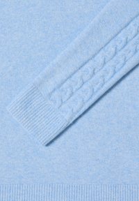 Maglione azzurro chiaro con motivo a treccia lungo le maniche, con polsini e orlo a coste per una maggiore texture e dimensione.