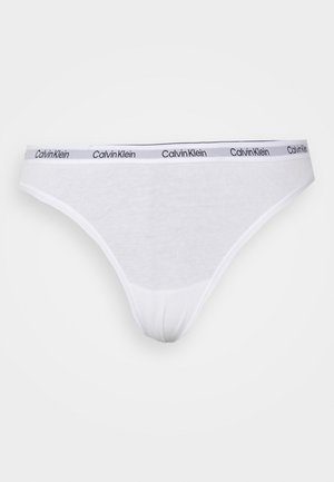Biela bavlnená tangá s úzkym pásom, na ktorom je čierny nápis "Calvin Klein". Jednoduchý dizajn s hladkou textúrou a strihom.