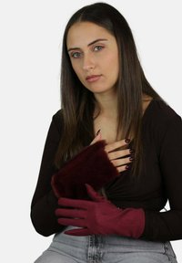 Guanti color bordeaux con polsino morbido e peloso dalla texture liscia, caratterizzati da un design aderente e copertura delle dita, adatti per il tempo freddo.