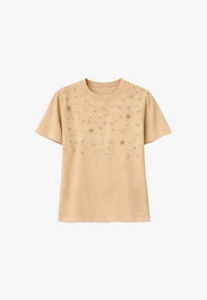 Beige T-shirt met korte mouwen, voorzien van kleine bloemrijke borduursels en kraalversieringen verspreid over de bovenkant van de voorkant.