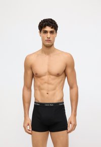 Czarne bawełniane bokserki z dopasowanym krojem i miękką teksturą. Posiadają czarny pas z białym logo "Calvin Klein".