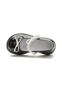 Scarpa in vernice nera con punta rotonda, decorazioni in nastro bianco e cinturino alla caviglia. Presenta una fodera interna liscia e una suola flessibile.