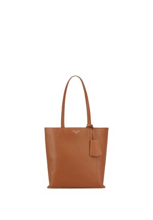 Sac fourre-tout en cuir marron avec longues poignées et étiquette attachée, présentant un nom de marque discret embossé près du centre supérieur.