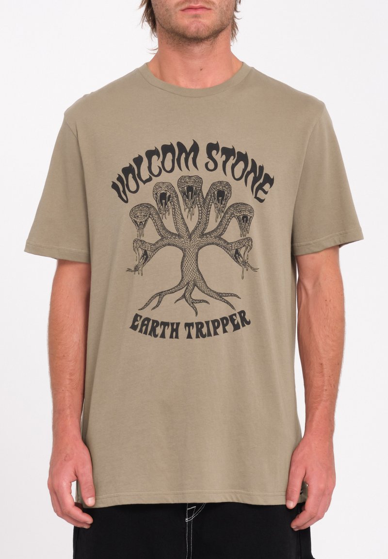 Oliven grøn bomulds t-shirt med et sort grafisk design af et slange-træ og teksten "VOLCOM STONE EARTH TRIPPER." Korte ærmer, afslappet pasform.