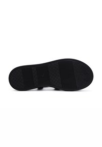 Black rubber shoe sole with a textured grip. Features horizontal and diamond-patterned segments for traction and stability.