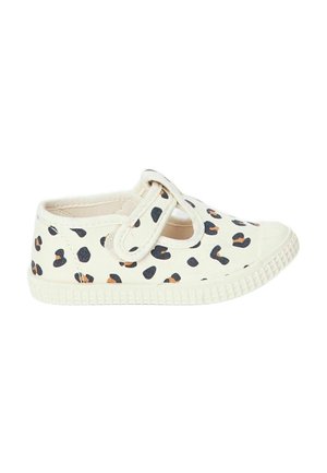 Chaussure en toile avec un bout rond, présentant un fond crème et un imprimé léopard noir et orange. Sangle réglable avec semelle texturée.