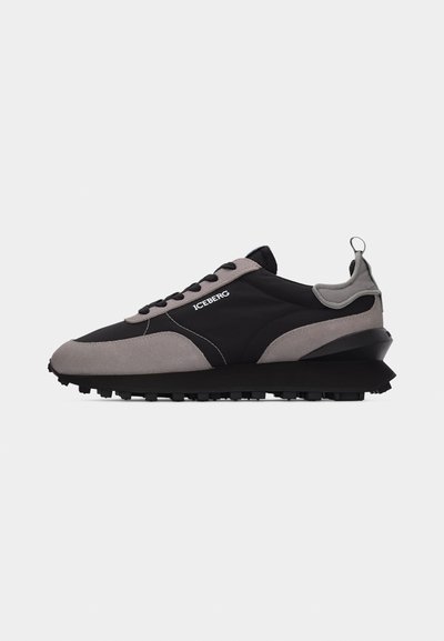 Μαύρο και γκρι sneaker ICEBERG με μαύρα κορδόνια, παχύ πέλμα με ανάγλυφη υφή και θηλιά στο τακούνι, εμφανιζόμενο από το πλάι σε λευκό φόντο.