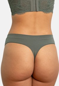 Olivgrüner Slip mit glatter Textur, niedrig sitzendem Bund und minimaler Abdeckung. Verfügt über ein einfaches und elegantes Design.