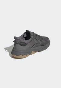 Thick-soled sneakers in dark gray mesh and rubber. Features textured upper, wavy design, and a rubberized heel accent.