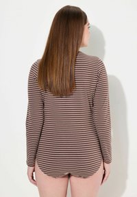 Maglietta a maniche lunghe a righe in marrone e crema, con orlo curvo e morbida texture. Progettata per una vestibilità comoda.