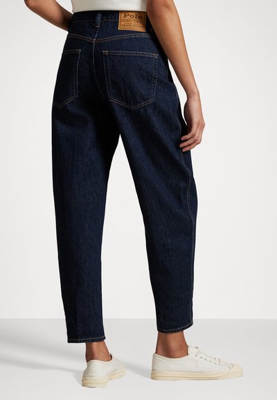 Urtaliga svarta jeans med hög midja, med två bakfickor och kontrasterande stickningar. Inkluderar en varumärkesläderlapp.