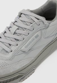 Grå Reebok-sneakers med en kombination av slät läder och strukturerad mocka, med ton-i-ton snören, en tjock sula och perforerade detaljer.