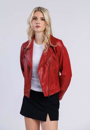 Veste de motard en cuir rouge au design ajusté, avec des revers pointus, une fermeture éclair et des épaules sans couture, portée par-dessus une chemise blanche à côtes.