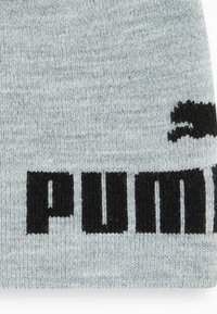 Berretto lavorato a maglia grigio con una texture morbida, caratterizzato da audace lettering nero "PUMA" e un piccolo logo nero.