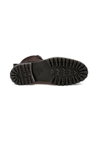 Botte en cuir marron avec une semelle en caoutchouc robuste dotée de profonds reliefs pour une meilleure adhérence. Fermeture à fermeture éclair sur le côté et accents cousus viennent détailler le design.