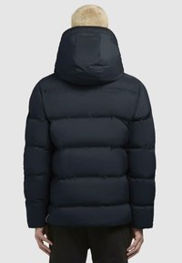 Giacca puffer navy con colletto alto e cappuccio oversize, caratterizzata da un design trapuntato e una texture liscia per l'isolamento.