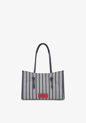 Bolso tote con rayas verticales en azul marino y blanco, con asas largas y una etiqueta rectangular roja con la inscripción "TOUS" en el centro delantero.