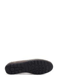 Zapato gris de ante sin cordones con una gruesa suela de goma negra. La suela presenta un patrón de agarre texturizado para tracción y estabilidad.