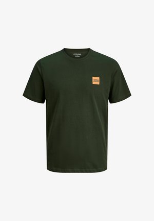 T-shirt in cotone verde scuro con colletto rotondo, maniche corte e un'etichetta quadrata di colore arancione sul lato sinistro del petto. Texture liscia.