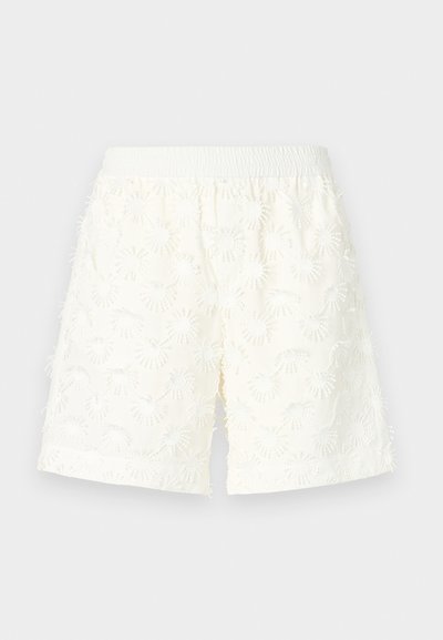 Hvide shorts med et struktureret blomstermønster, elastisk talje og frynsede kanter. Fremstillet af letvægtsstof, velegnet til varmt vejr.